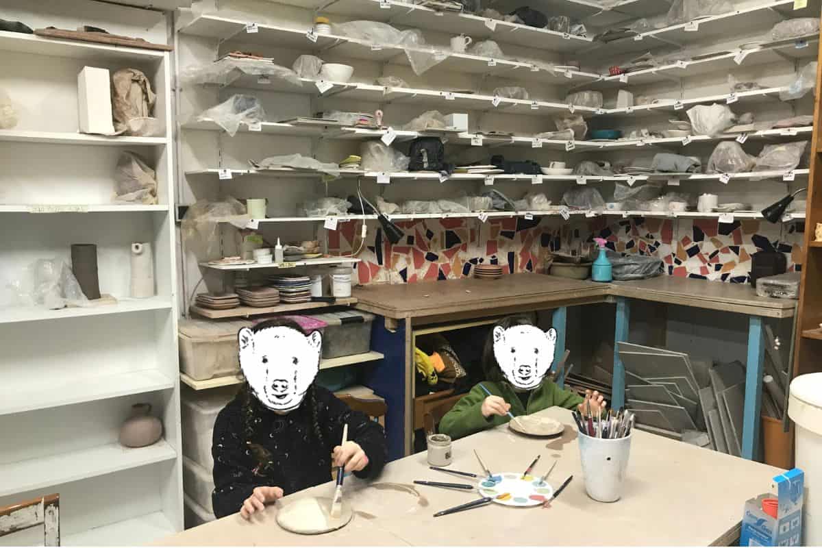 Two kids painting ceramic plates at Amasarte in Madrid