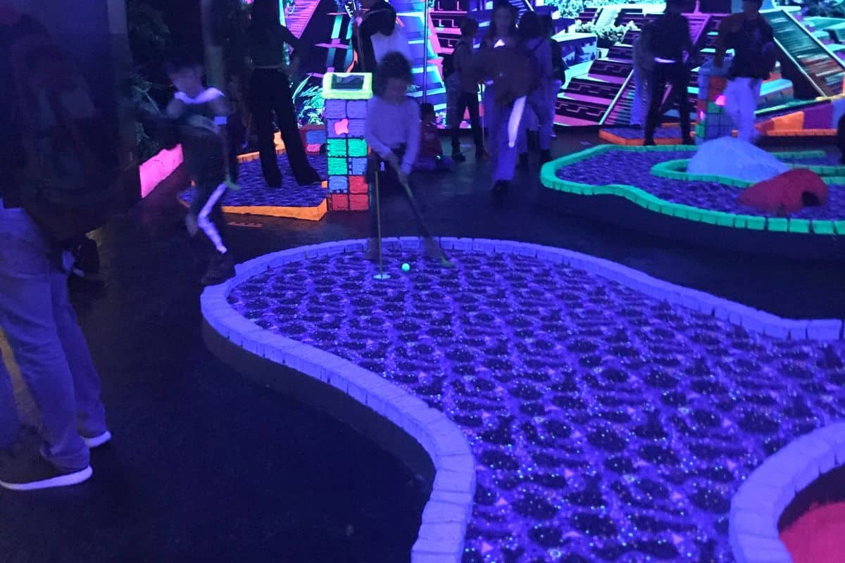 Families playing minigolf in the dark in Madrid