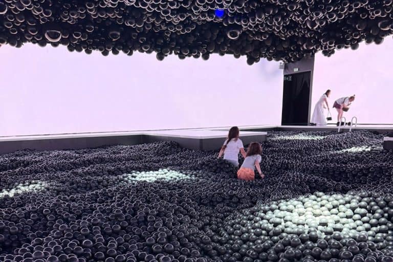 Two kids walking through a ball pit at the Balloon Museum in Madrid