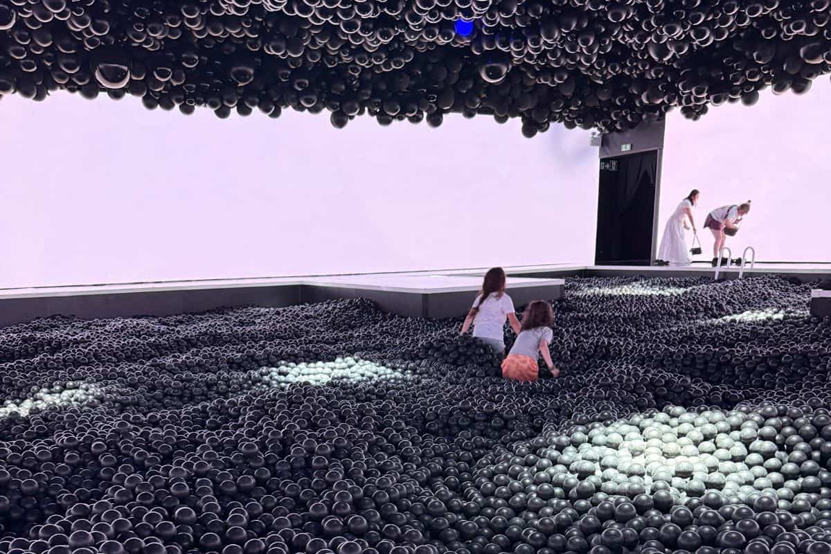 Two kids walking through a ball pit at the Balloon Museum in Madrid