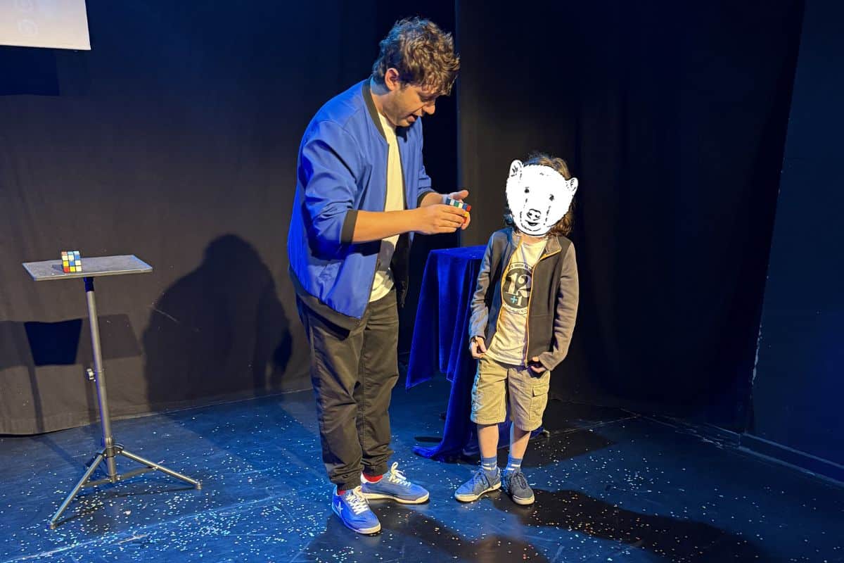 A trick being performed with a boy at a magic show in Madrid