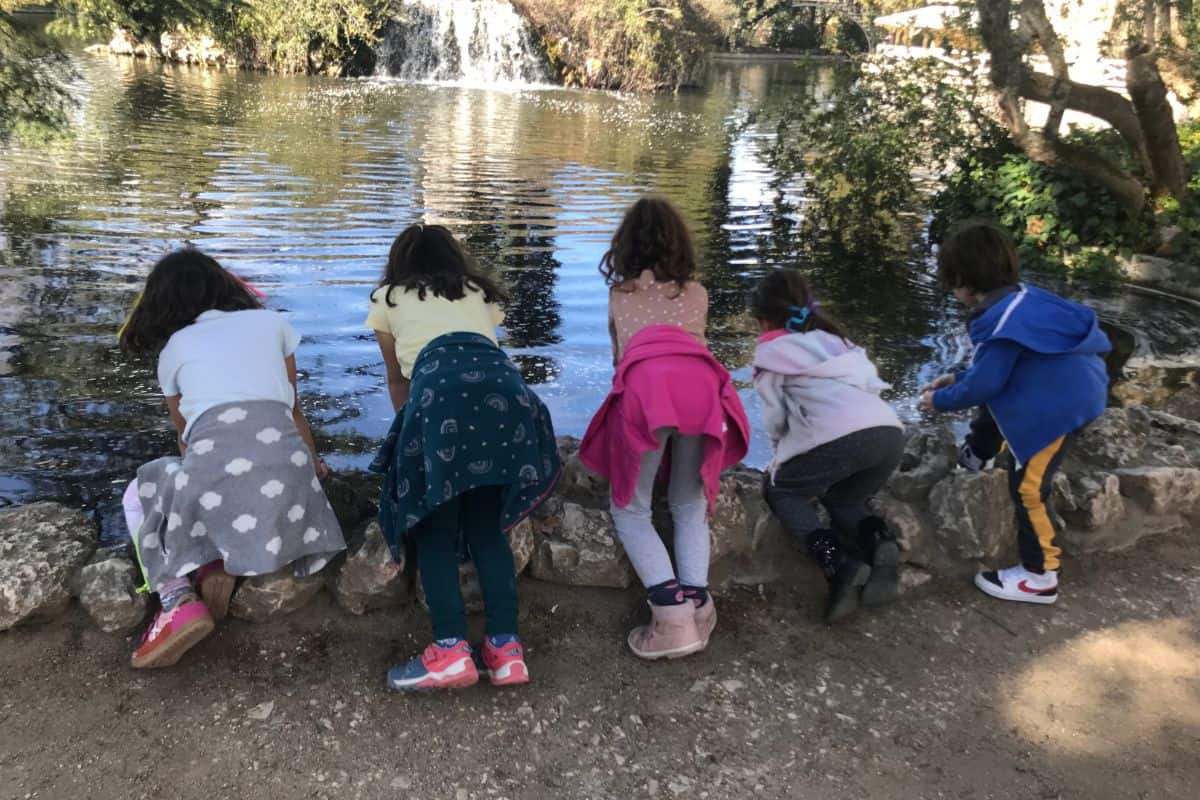Kids looking in a pond at Parque Capricho in Madrid